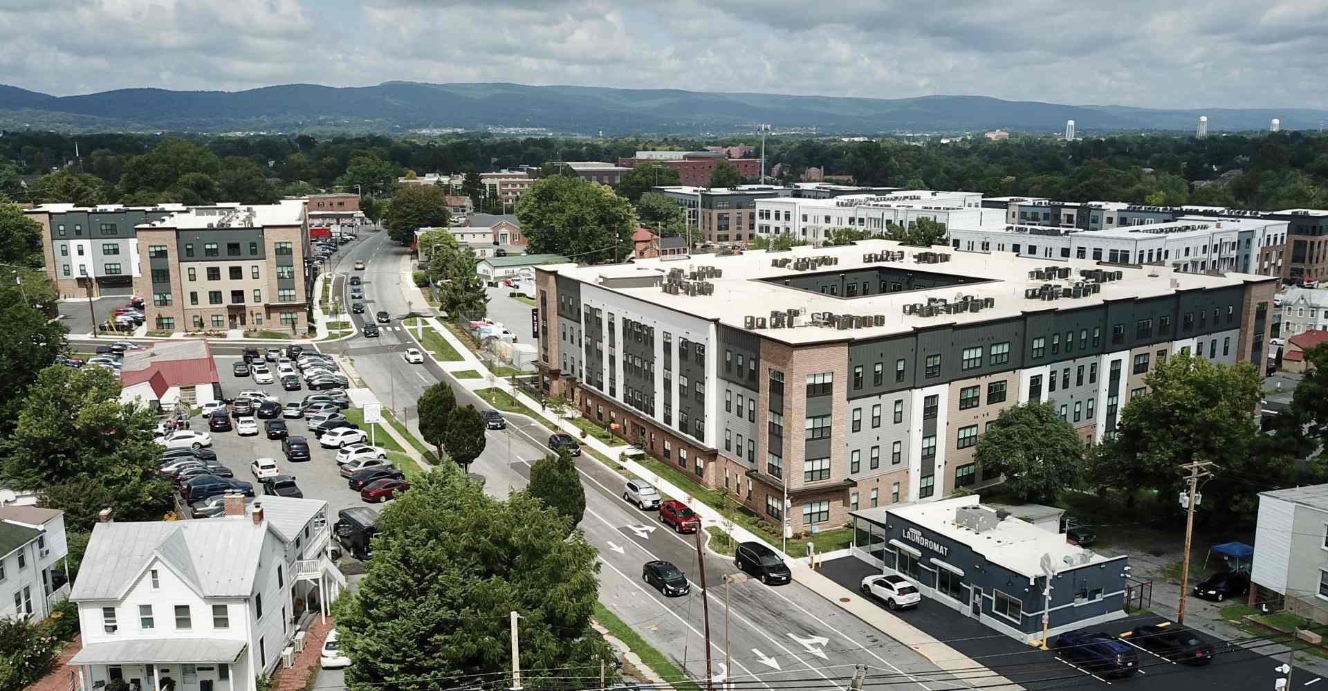 Aerial view of The Junction apartment complex in Frederick, MD, surrounded by streets, parking, and mountains in the distance.